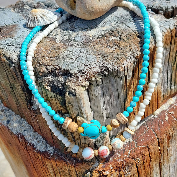 Super sweet turquoise natural matt calcite stone bead necklace with wood discs & cute turtle.  The necklace has silver plated fastenings, lobster clasp & silver hanging shell (nickel free)  Length - 41cm  Perfect little gift for any beach lover!  **Presented in lovely Kraft paper gift box with reusable organza pouch**  **To keep your quaypieces looking great, always take me off before showering or swimming**
