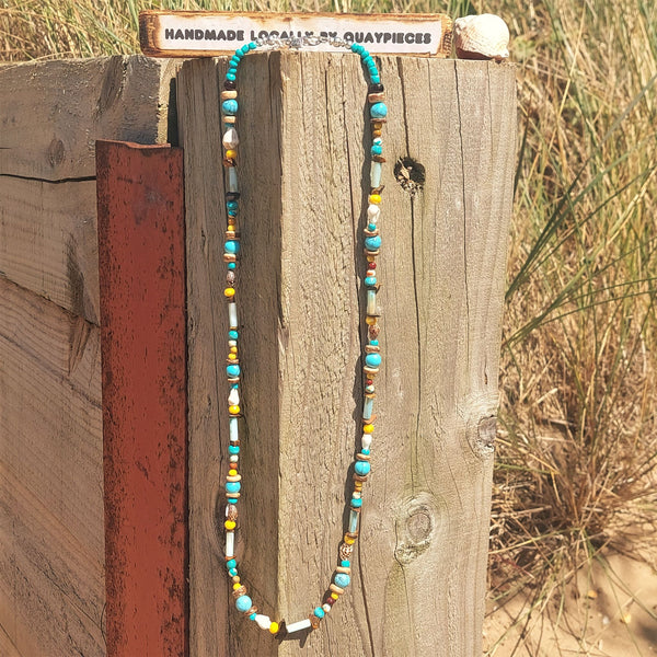 A super cool long bead surf necklace in lovely blue, yellow & brown colours. A Perfect addition to all your Summer outfits. A combination of natural stone, shell, calcite, wood & silver hematite beads Silver plated fastenings & clasp with silver (nickel free) 'made with love' heart & little turtle charm length 74cm Gift wrapped & presented in a pretty organza pouch
