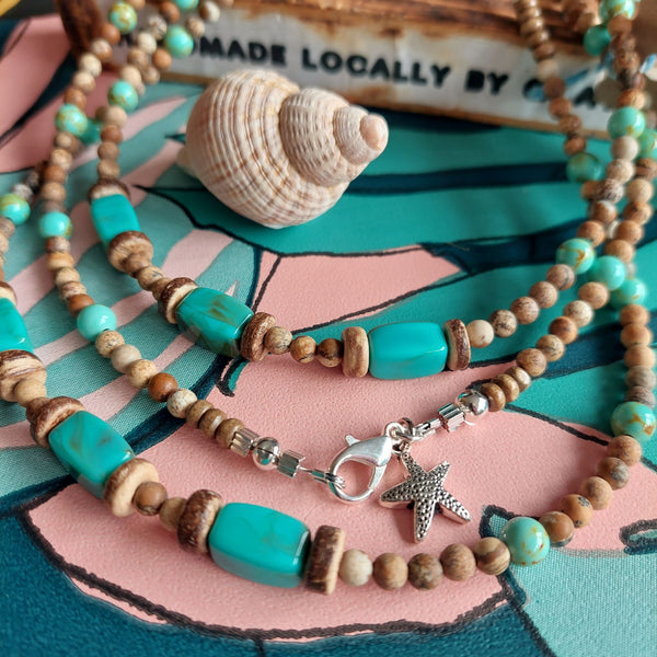 Lovely tawny colour stone beaded necklace with chunky oblong turquoise tubes & coconut discs.  The necklace has silver plated fastenings, lobster clasp & silver hanging starfish (nickel free)  Length - 41cm  Perfect surf style accessory with winter Tees!  **Presented in lovely Kraft paper gift box with reusable organza pouch**