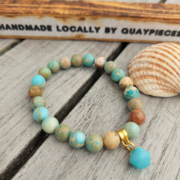 Gorgeous Aqua Blue & Terracotta marble effect natural stone beaded bracelet with bue & gold plated marble hexagonal charm  ﻿﻿Each bracelet will be unique due to varying colour shades of the stone beads  Elasticated, so will fit most adult wrists (measuring 71/2 in/19cm)  **Presented in lovely Kraft paper gift box with reusable organza pouch**  **To keep your quaypieces looking great, always take me off before showering or swimming. Avoid over stretching by rolling the bracelet on & off your wrist**