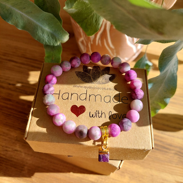 Lovely 8mm Matt Natural Stone Bead Bracelet in shades of Purple with gold plated cube charm  Elasticated, so will fit most adult wrists (measuring 71/2 in/19cm)  Perfect for wearing with those Christmas outfits & a lovely gift for friends or family  **Presented in lovely Kraft paper gift box with reusable organza pouch**