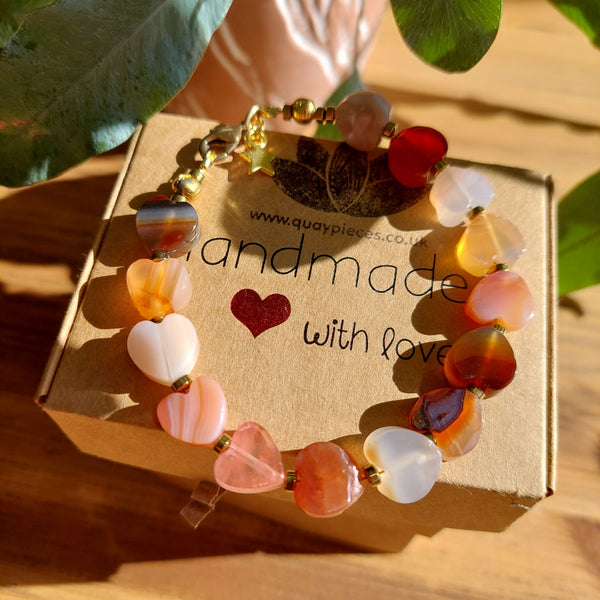Gorgeous Natural Stone Heart Bracelet in various amber tones separated with gold plated hematite beads & fastenings plus star charm.  Length - 20cm  Because this is a natural product, no bead is the same  Super gift or a treat for yourself!  **Presented in lovely Kraft paper gift box with reusable organza pouch**  **To keep your quaypieces looking great, always take me off before showering or swimming. **