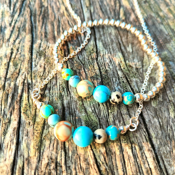 4mm Sterling Silver with ocean shades of blue natural stone & dalmatian Jasper beads﻿﻿  Super cute bracelet to wear alone or as a stack!  Elasticated, so will fit most adult wrists (measuring 7.5 in/19cm)  **Presented in lovely Kraft paper gift box with reusable organza pouch**  **Will not tarnish if cared for properly**