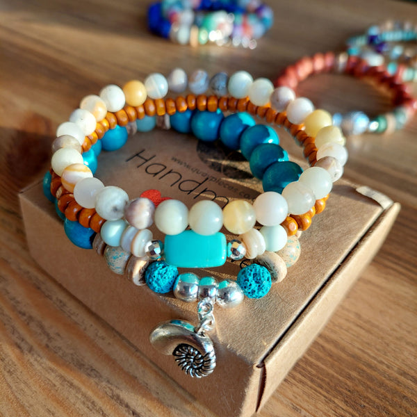 <p data-mce-fragment="1">Handcrafted Collection of 3 Wood &amp; Stone Beaded Bracelets</p> <p data-mce-fragment="1">Each Bracelet is individually designed, (1) 8mm turquoise wood &amp; aqua green stone beads, coconut discs, &amp; spiral shell charm (nickel free), (2) 6mm multicolour aqua agate stone beads plus (3) 4mm orange wood beads with shell discs &amp; silver plated hematite beads</p> <p data-mce-fragment="1">Elasticated, so will fit most adult wrists (measuring 7.5 in/19cm)</p>