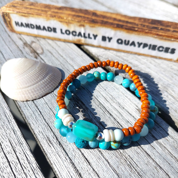 Handcrafted Collection of 2 Wood &amp; Stone Beaded Bracelets  Each Bracelet is individually designed with a combination of 6mm &amp; 4mm wood, stone, shell, lava &amp; silver plated beads.   Choose from 2 colourways Blue/orange or Green/brown  Elasticated, so will fit most adult wrists (measuring 7.5 in/19cm)