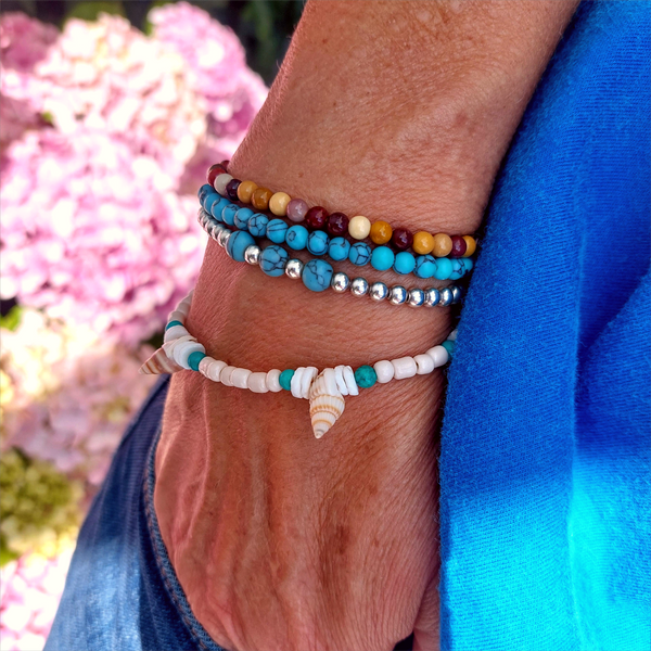 Gorgeous delicate bracelet, great for stacking or wear alone for a beach look!  Ivory seed beads, turquoise calcite, puka shells &amp; little spiral shells  Each bracelet has gold plated fastenings &amp; lobster clasp with super cute turtle charm &amp; extension chain  Lenght 20cm extending to 23cm&nbsp;  Perfect gift for any surf chick!