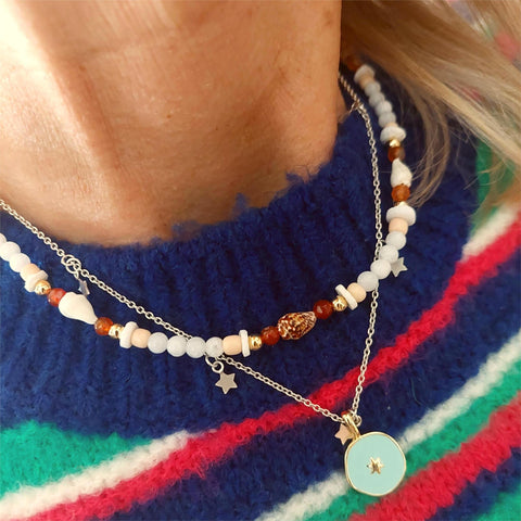 Add some ocean vibes to your look with this handmade necklace of white jade, gold plated and amber agate beads, accompanied by shell discs and fun spiral shells. The gold plated fastenings and clasp with extension chain, adorned with star and shell charms, make it just the right length at 40cm (42cm with extension chain). Wear it alone for a beachy look or stack it with your other favourite accessories! Ocean fun, ready to be worn!