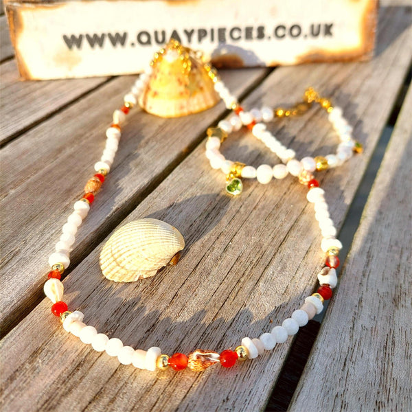 Add some ocean vibes to your look with this handmade necklace of white jade, gold plated and amber agate beads, accompanied by shell discs and fun spiral shells. The gold plated fastenings and clasp with extension chain, adorned with star and shell charms, make it just the right length at 40cm (42cm with extension chain). Wear it alone for a beachy look or stack it with your other favourite accessories! Ocean fun, ready to be worn!