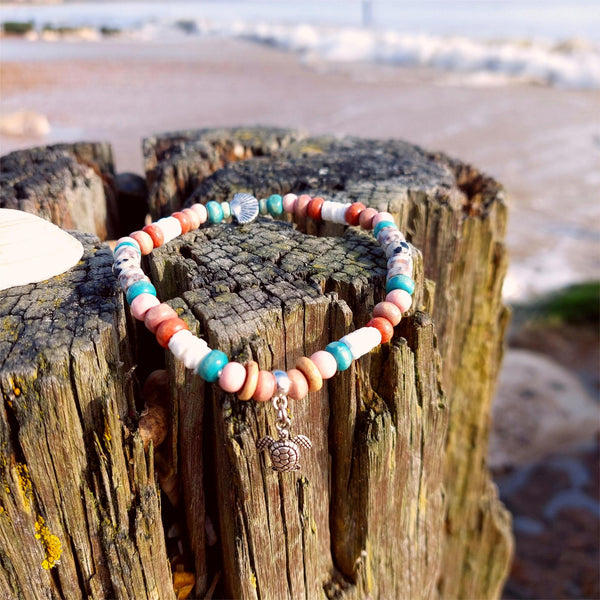 Inject some serious beach vibes into your look with this handcrafted anklet featuring wood, stone, and puka shell beads. The silver plated shell and turtle add a unique touch. Elasticated at 23cm/9ins, it's a cool gift for any surf chick!