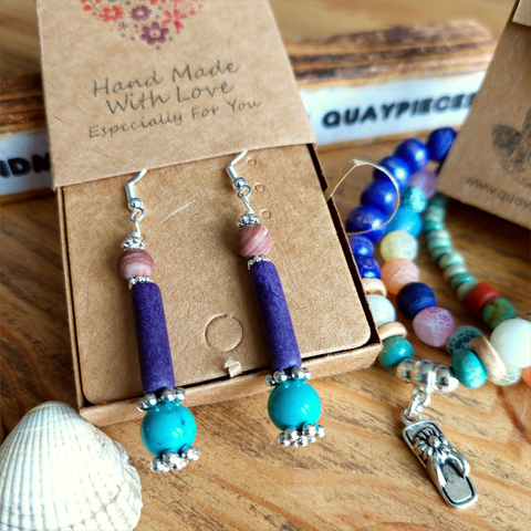 Lovely ethnic style earrings handmade with natural stone bead, plum colour ceramic tube &amp; turquoise magnesite bead separated with silver plated flower discs


925 Sterling Silver Hook

Length 42mm from bottom of hook

Add a bit of colour to your day!