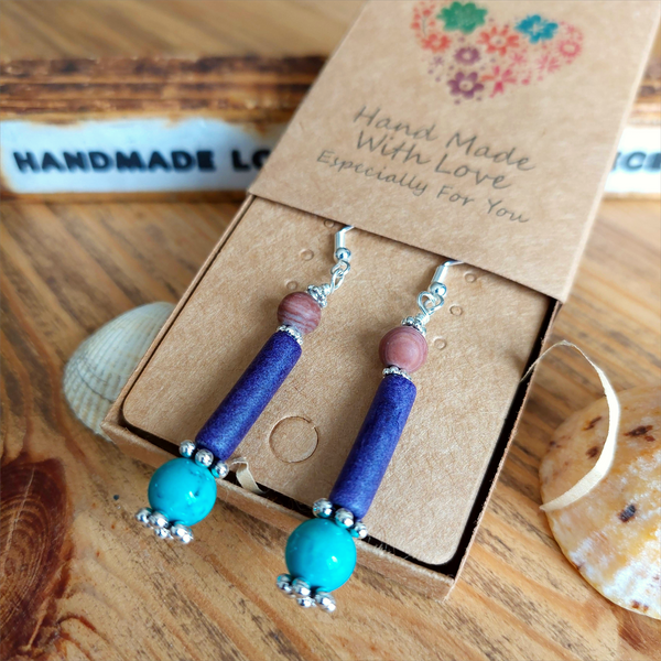 Lovely ethnic style earrings handmade with natural stone bead, plum colour ceramic tube &amp; turquoise magnesite bead separated with silver plated flower discs


925 Sterling Silver Hook

Length 42mm from bottom of hook

Add a bit of colour to your day!