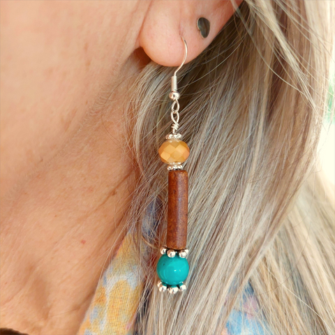 Lovely ethnic style earrings handmade with peach faceted bead, coffee colour ceramic tube &amp; turquoise magnesite bead separated with silver plated flower discs


925 Sterling Silver Hook

Length 42mm from bottom of hook

Add a bit of colour to your day!