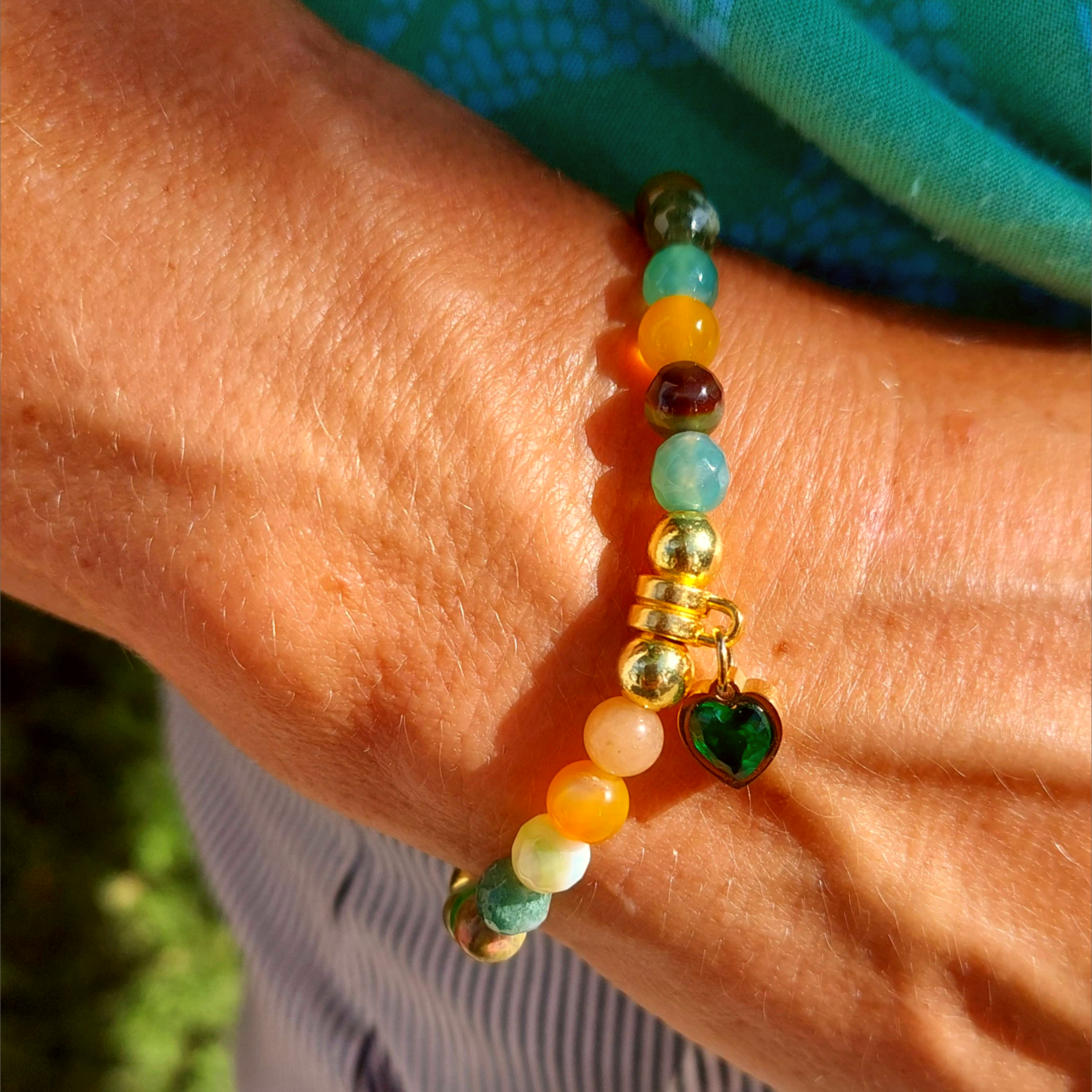 Lovely Handmade 6mm gemstone bracelet with agate, glass &amp; gold plated beads in seasonal multicolour greens &amp; ambers with a gorgeous dark green cubic zirconia heart charm.


Elasticated, so will fit most adult wrists (measuring 7.5in/19cm)


A great addition to your winter outfits!

**Presented in lovely Kraft paper gift box with reusable organza pouch**
