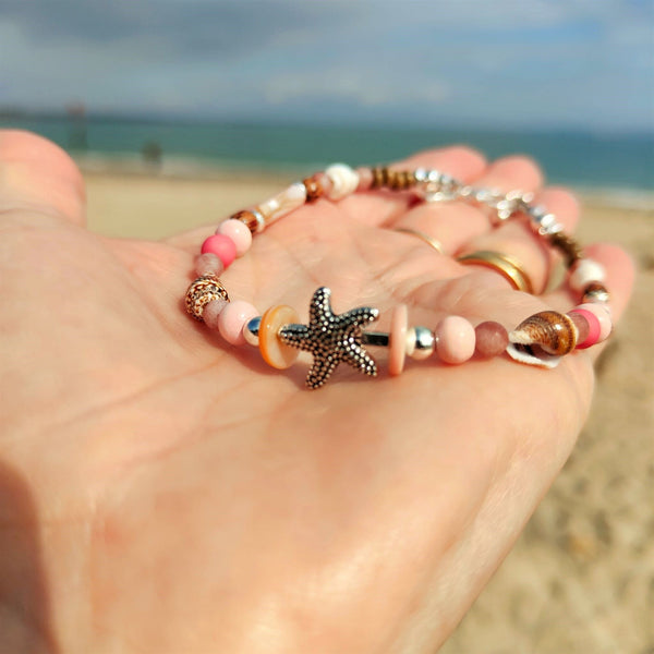 ﻿Put your best foot forward on the beach!  Cute handmade anklet with a combination of spiral shells, silver hematite, wood & stone beads with pink shell tubes & silver (nickel free) Starfish  Each anklet has sterling silver plated fastenings, lobster clasp & made with love heart charm with extension chain to adjust the length.  Length - 24cm extends to 27cm   **Presented in lovely Kraft paper gift box with reusable organza pouch**