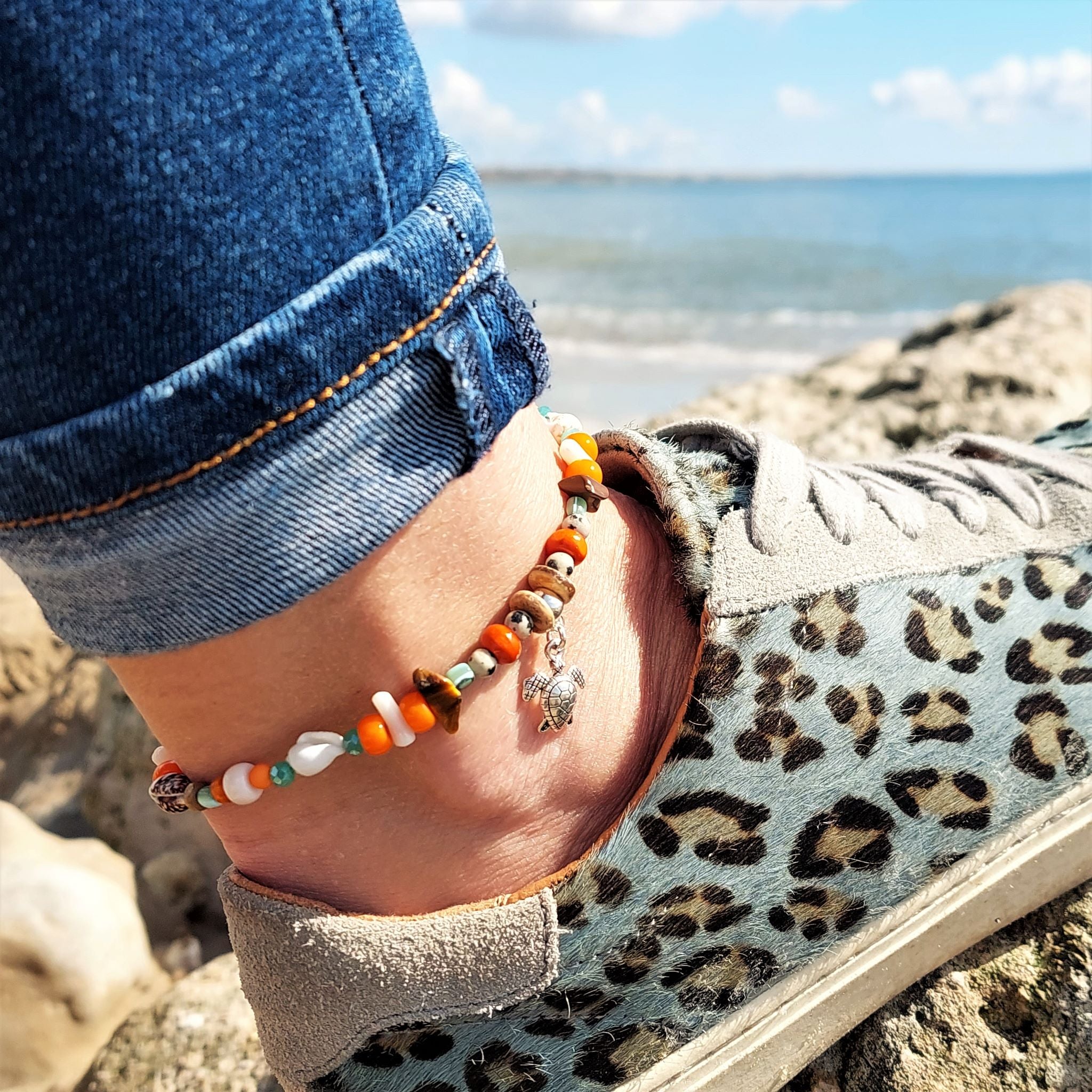 Cute handmade anklet with a combination of spiral shells, green & dalmatian jasper beads with stone chips, orange discs & silver (nickel free) Turtle & Starfish  Each anklet has sterling silver plated fastenings, lobster clasp & extension chain to adjust the length.  Length - 24cm extends to 27cm  Add a bit of boho beach chic to your ankles this Summer!